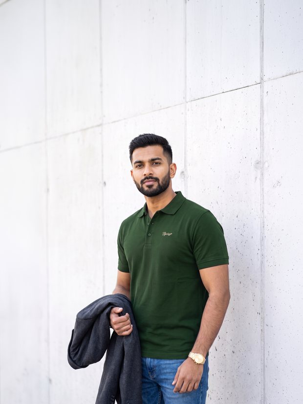 Man in a Forest Green PurEase polo against a concrete wall