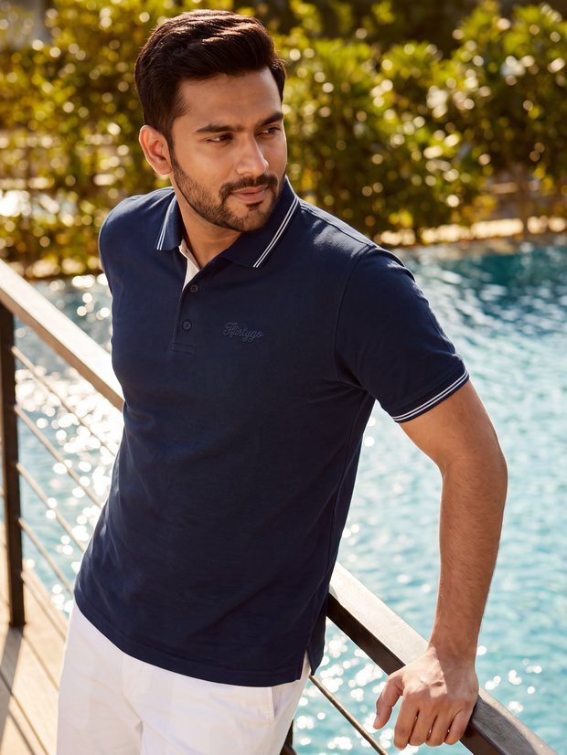 Man in a Midnight Navy twin-tipped PurEase polo beside a pool